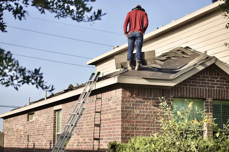 Professional roofer working on a residential roof in Llanfair